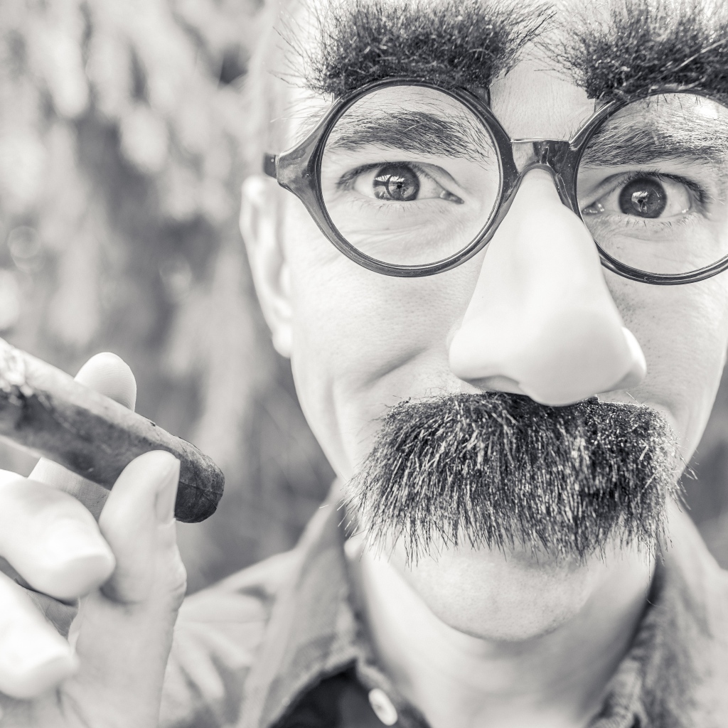 Мужчина в очках с сигарой в руке