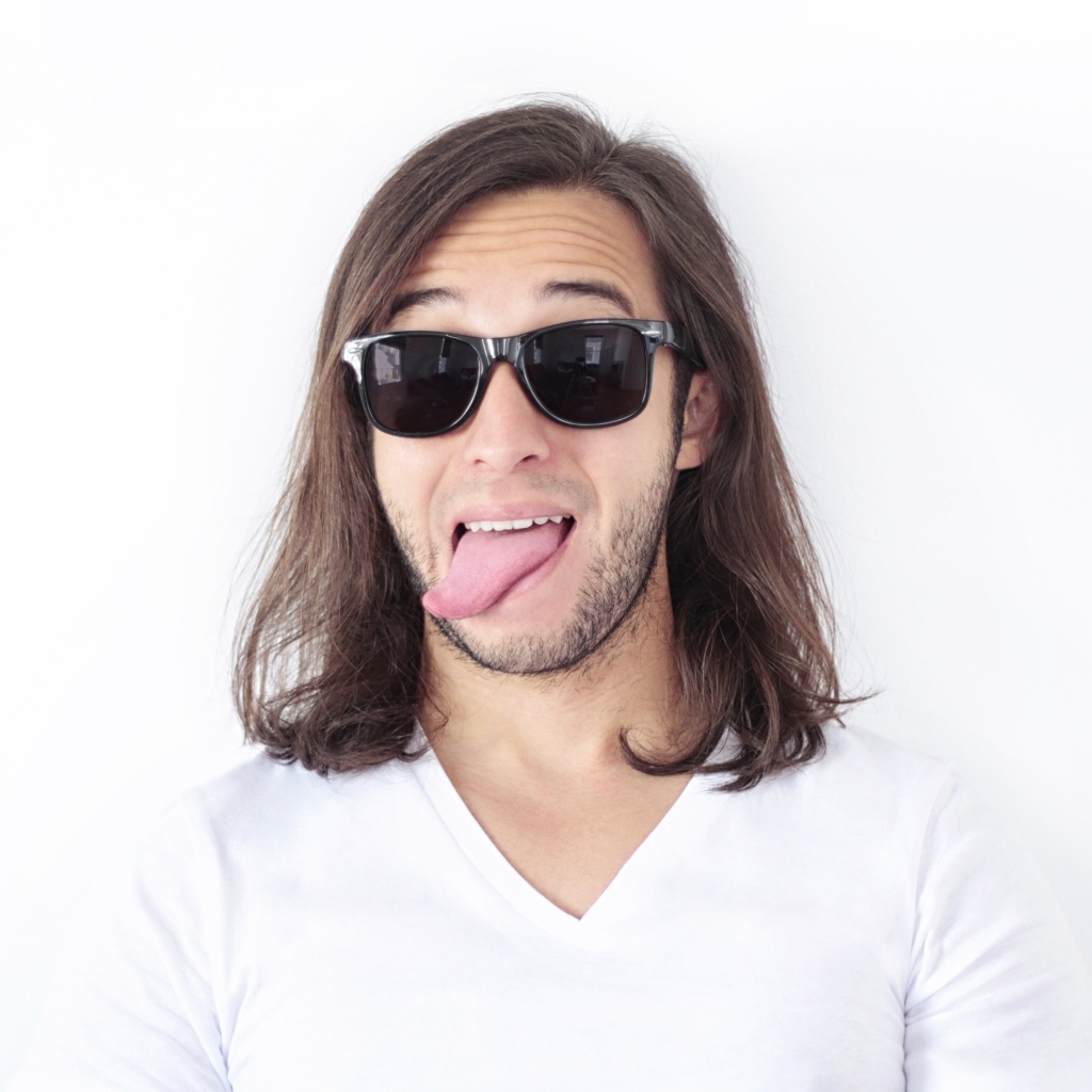 Мужчина в очках с высунутым языком