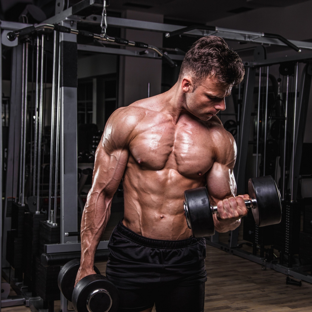 Сильный мужчина качает мускулы 