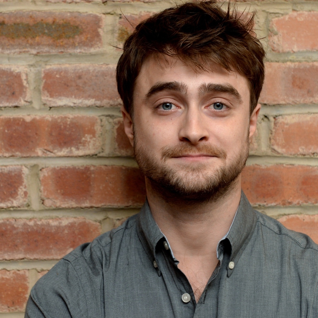 Актер Дэниел Рэдклифф стоит у стены