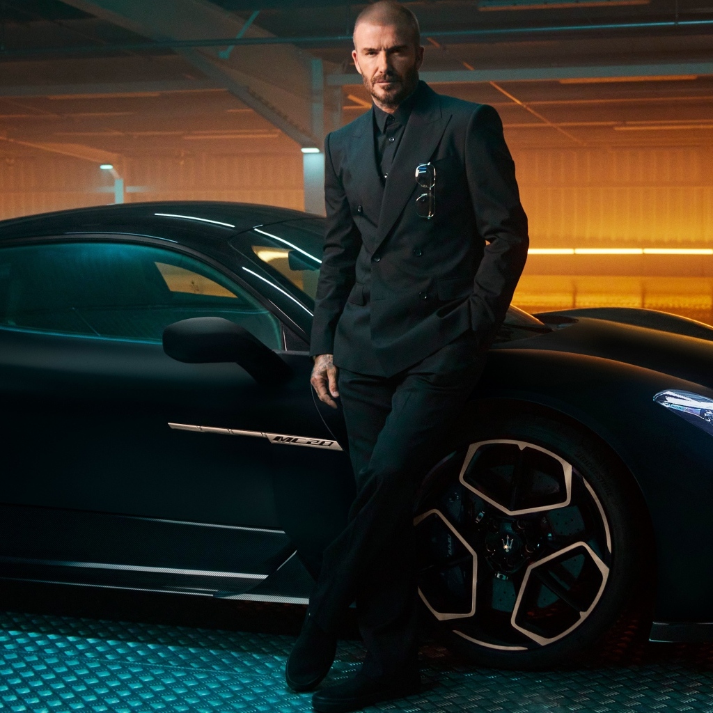 Футболист Дэвид Бекхэм у черного автомобиля Maserati MC20