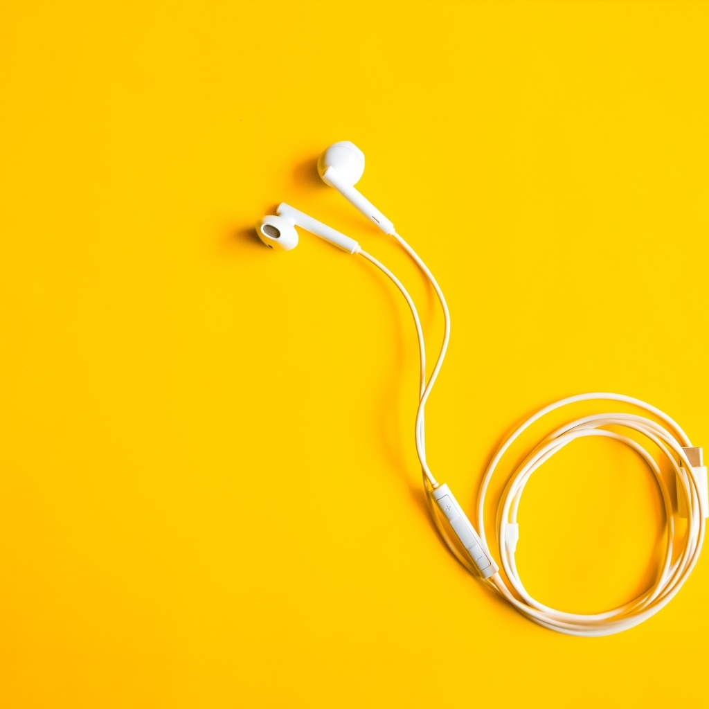 Белые наушники на желтом фоне