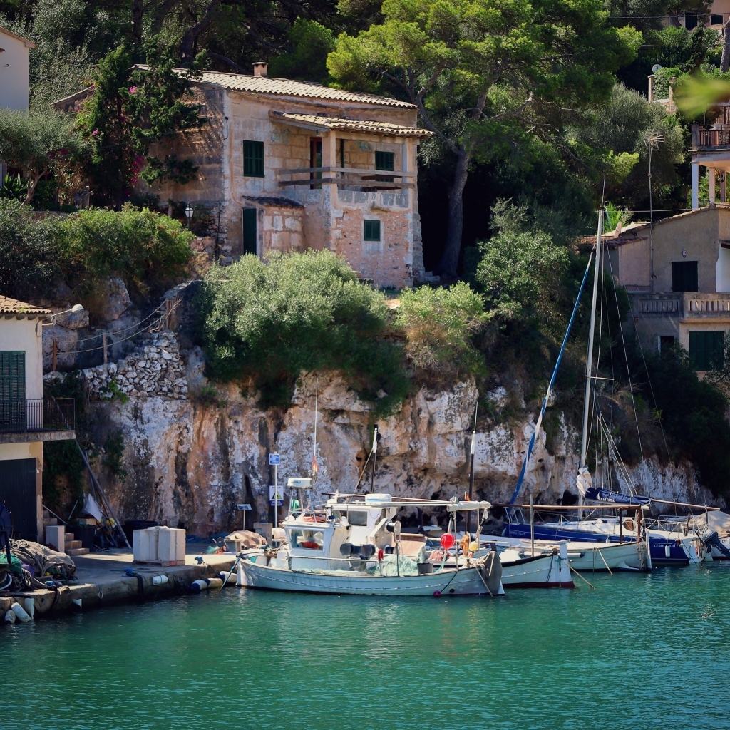 Лодки в воде у причала у домов