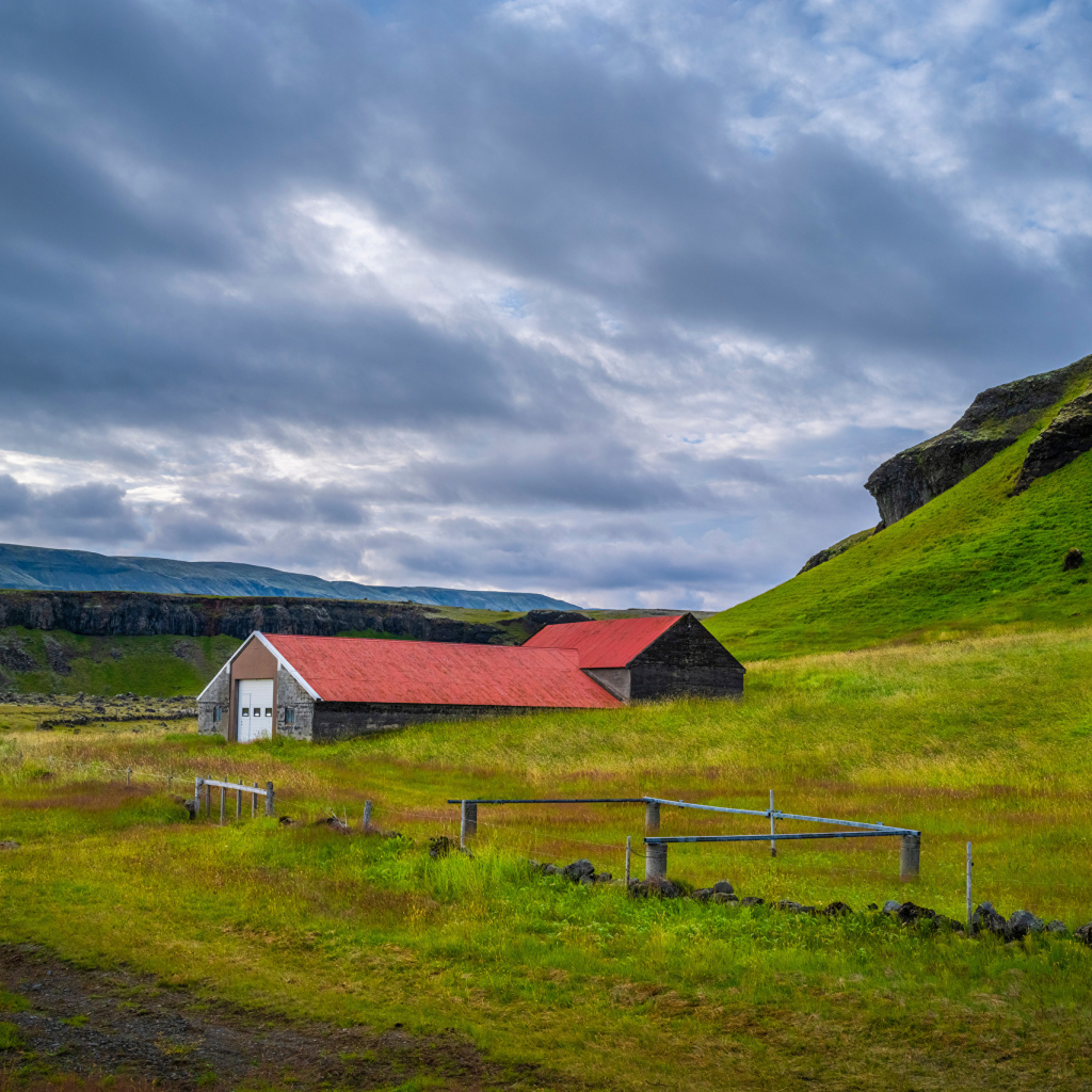 Дом у покрытой зеленью поры под грозовым небом