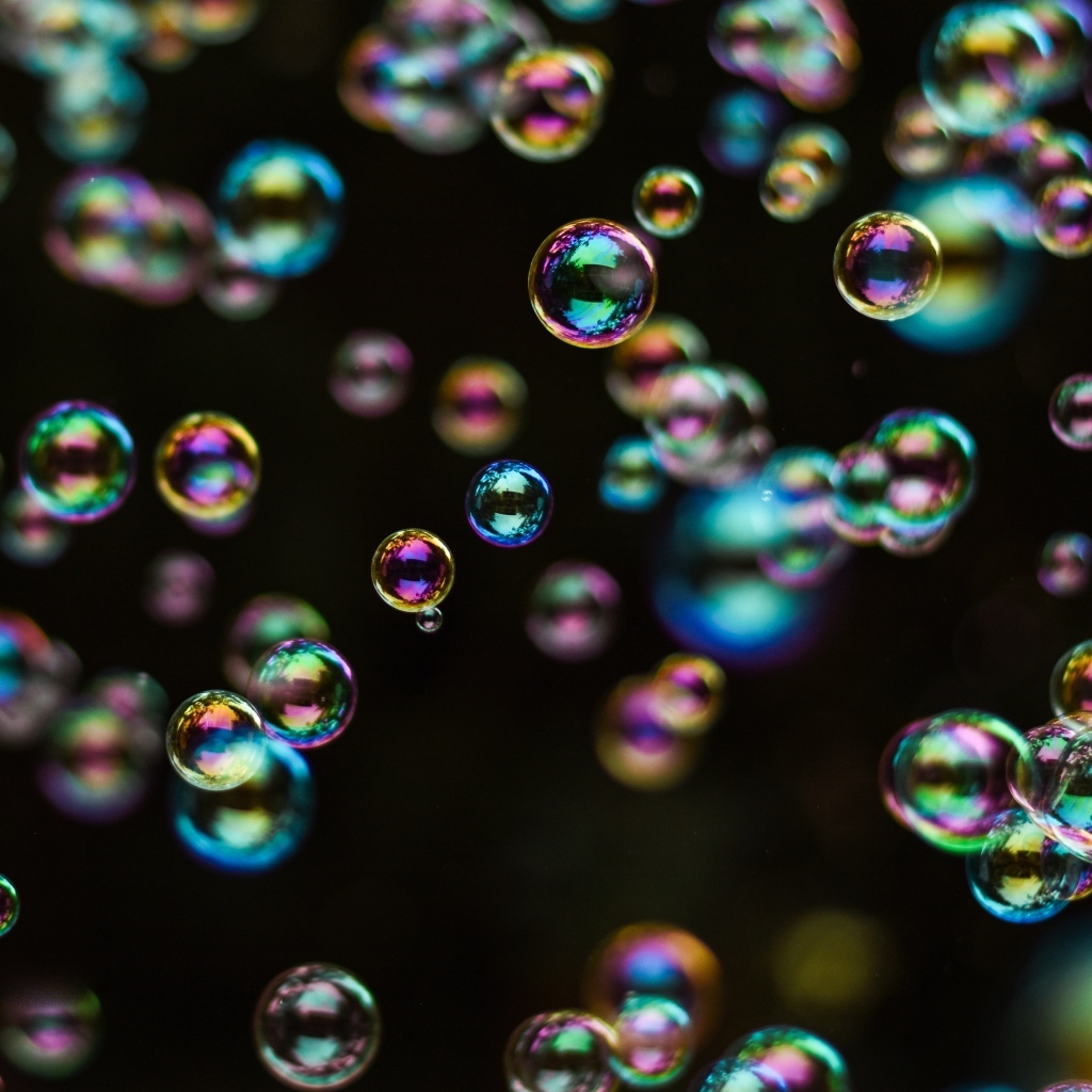 Разноцветные мыльные пузыри на черном фоне