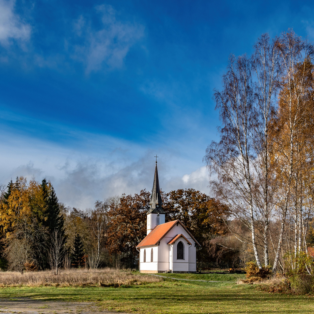 Старая часовня в парке под красивым голубым небом