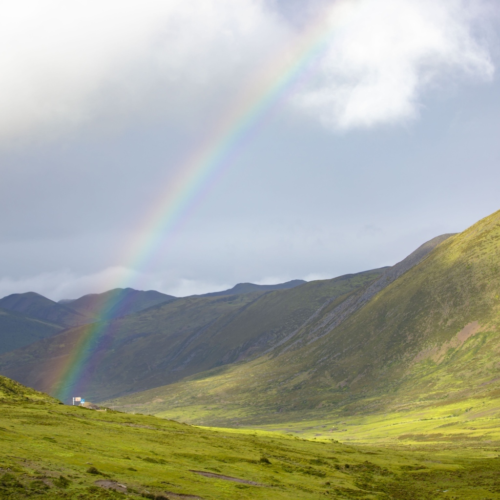 Радуга над покрытыми зеленью холмами