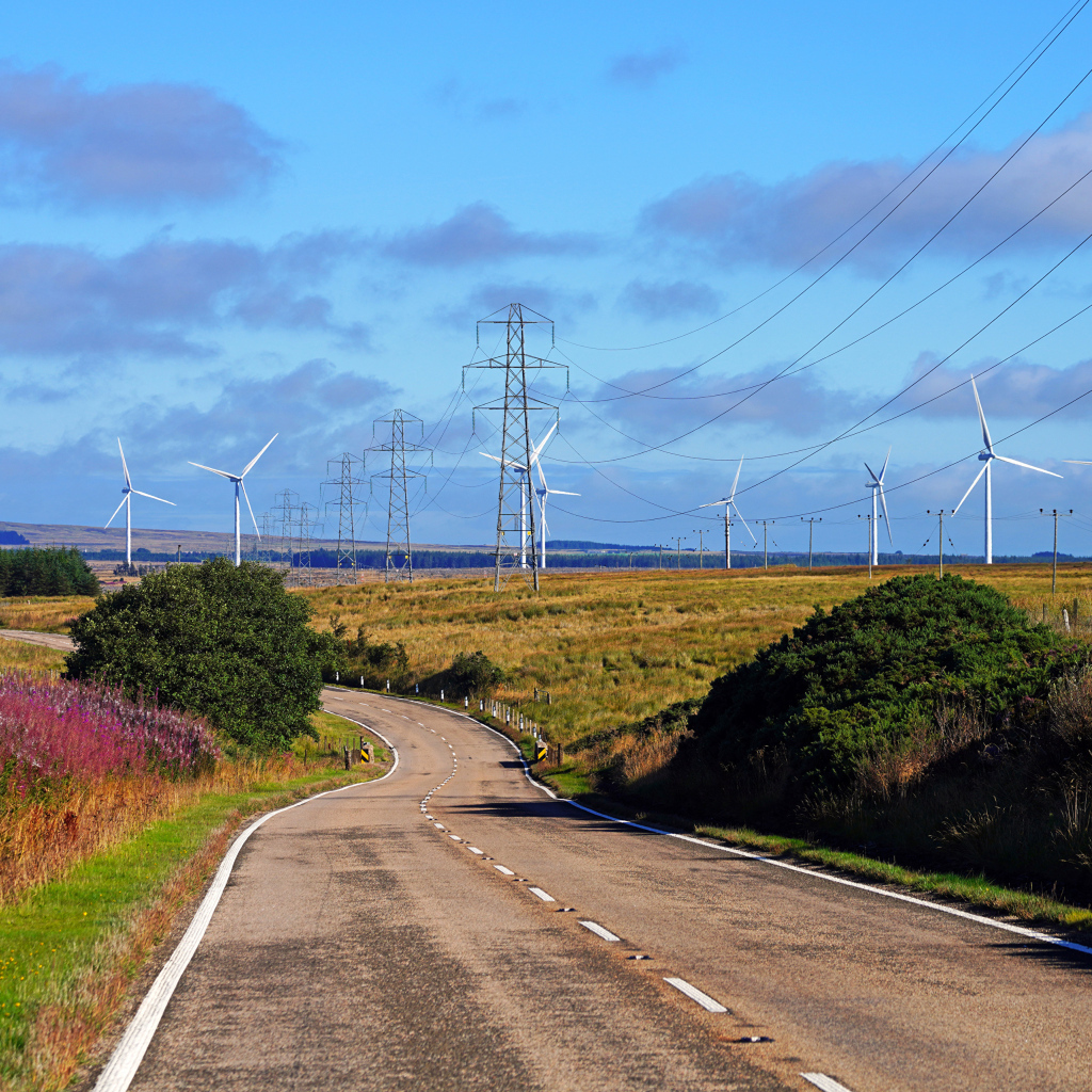 Ветрогенераторы в поле у дороги под голубым небом
