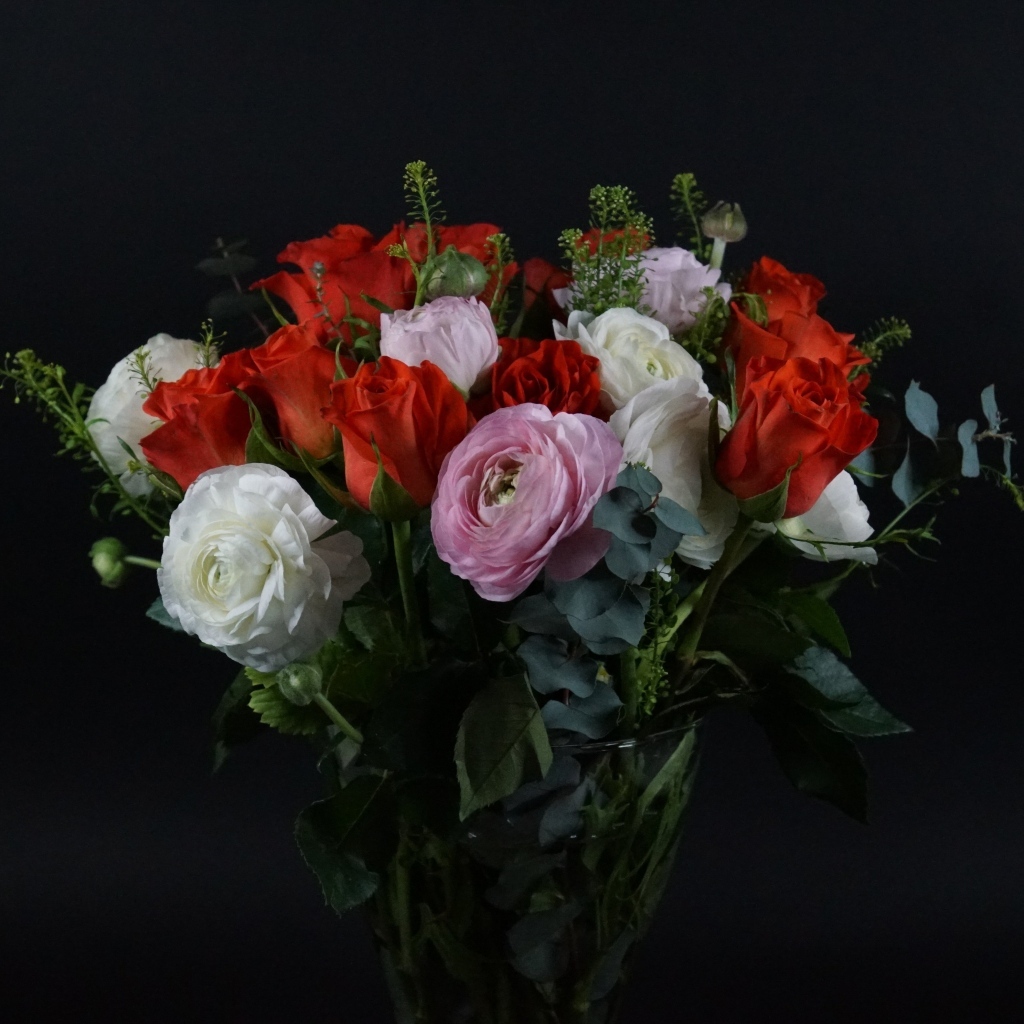 Красивый букет с цветами лютика и красной розы на черном фоне