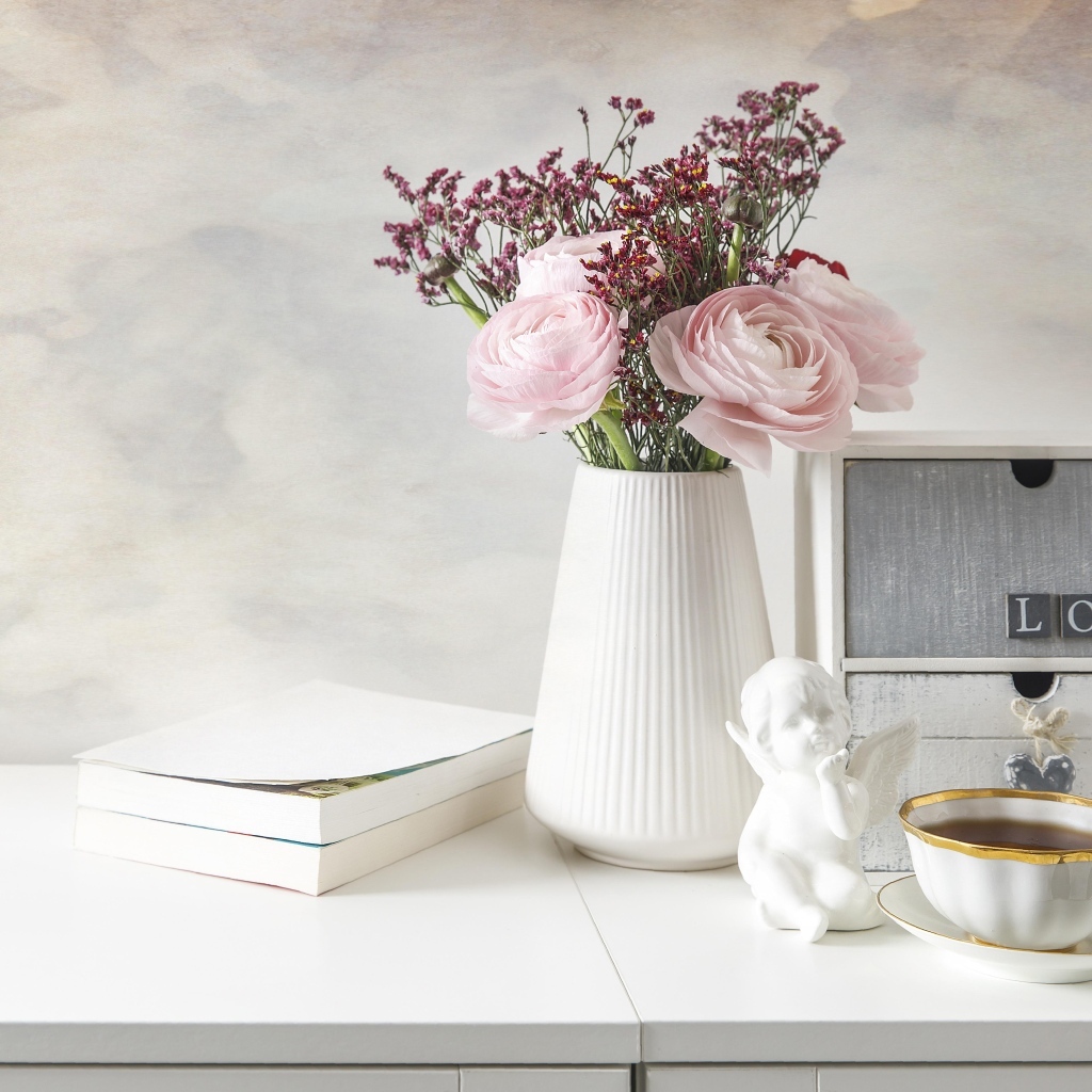 Букет розовых лютиков в вазе на столе