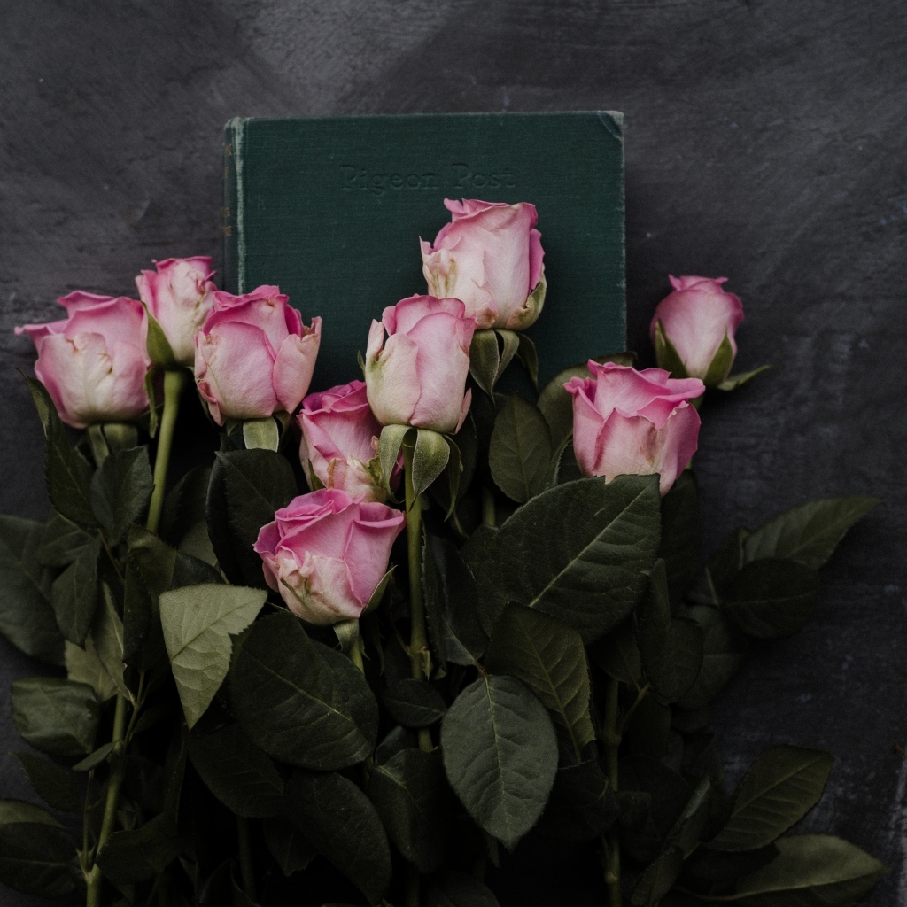 Букет розовых роз с книгой на сером столе