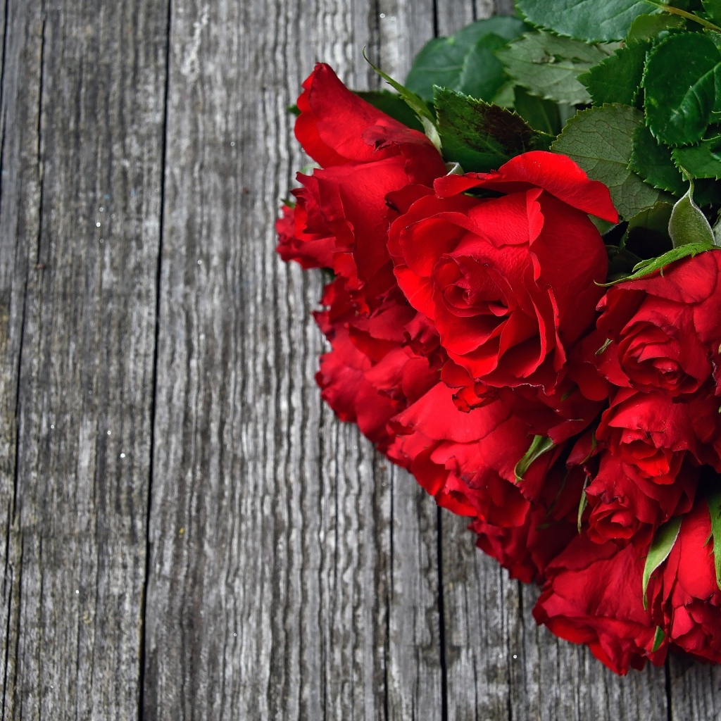 Букет красных роз на деревянном столе