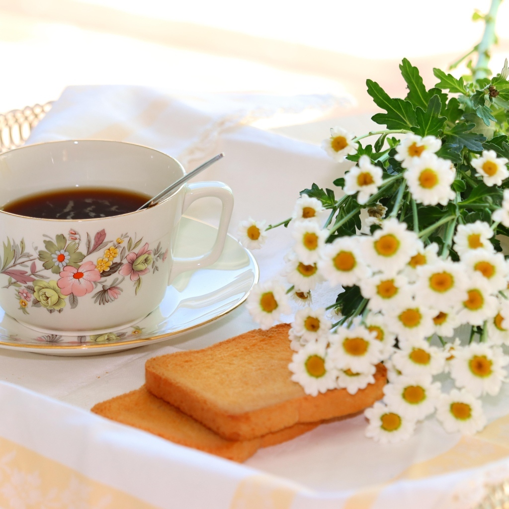 Букет белых ромашек с чашкой чая  и хлебом