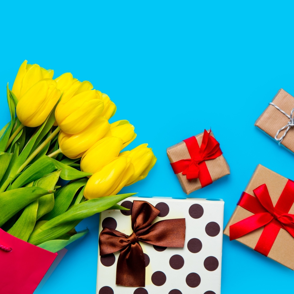 Букет желтых тюльпанов с подарками на голубом фоне