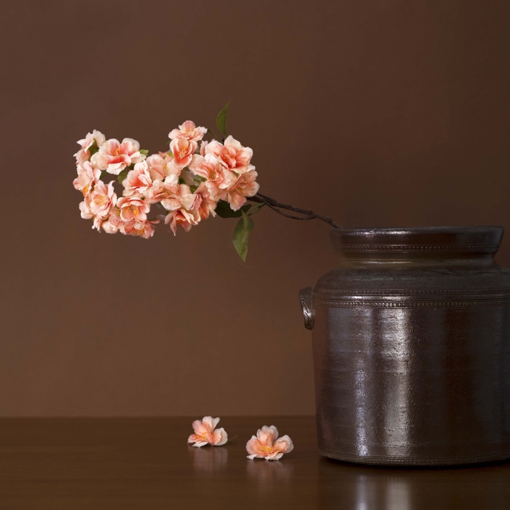 Ветка с розовыми цветами в вазе на столе