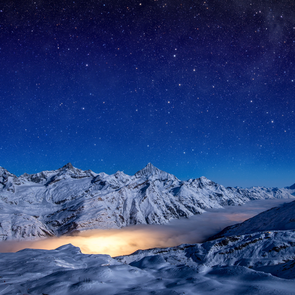 Красивое ночное небо над покрытыми снегом горами