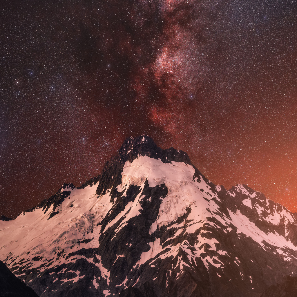 Заснеженная вершина горы под звездным небом