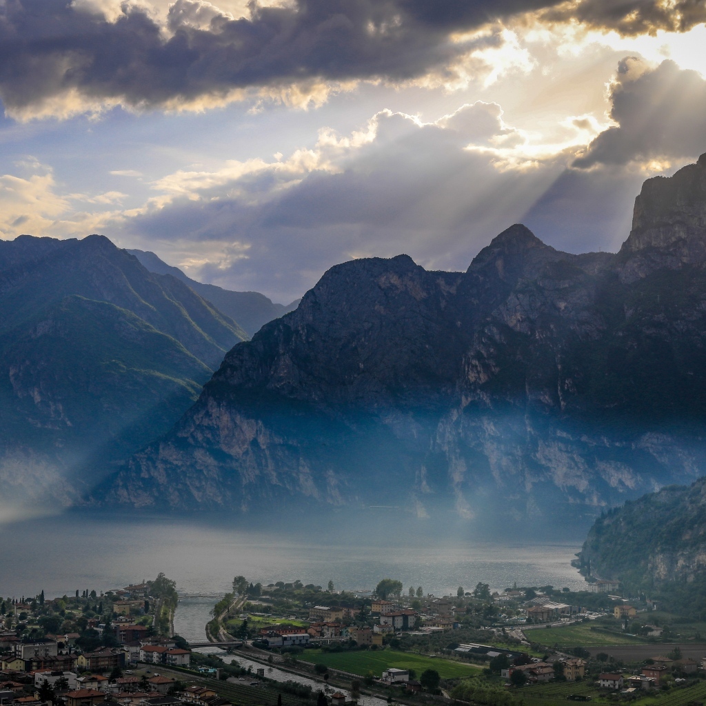 Лучи солнца покрывают горы и город 
