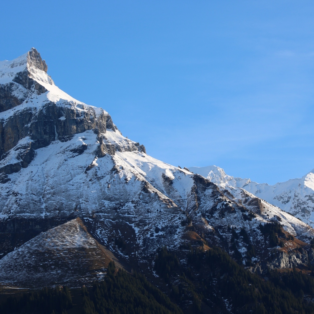 Вершина горы покрыта снегом в лучах солнца