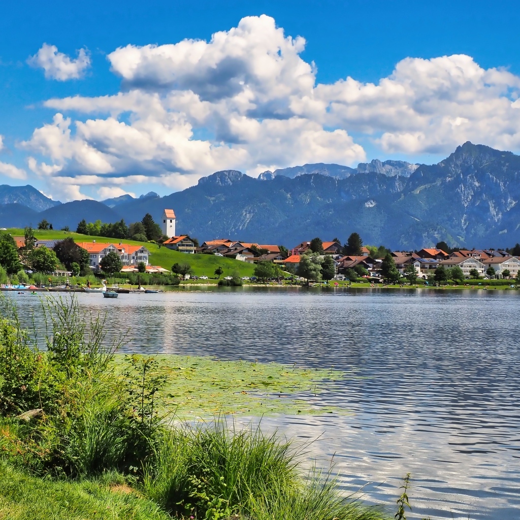 Красивый вид на озеро и горы под голубым небом с белыми облаками