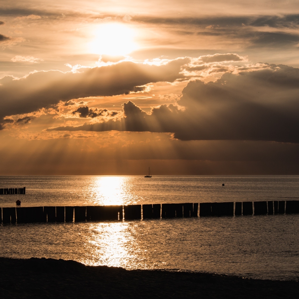 Яркое солнце за облаками над морем