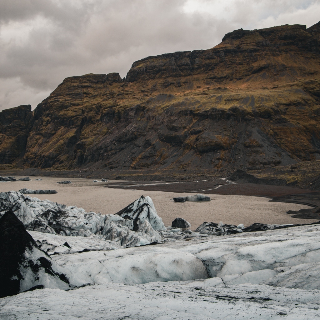 Холодный грязный снег на берегу моря у гор 