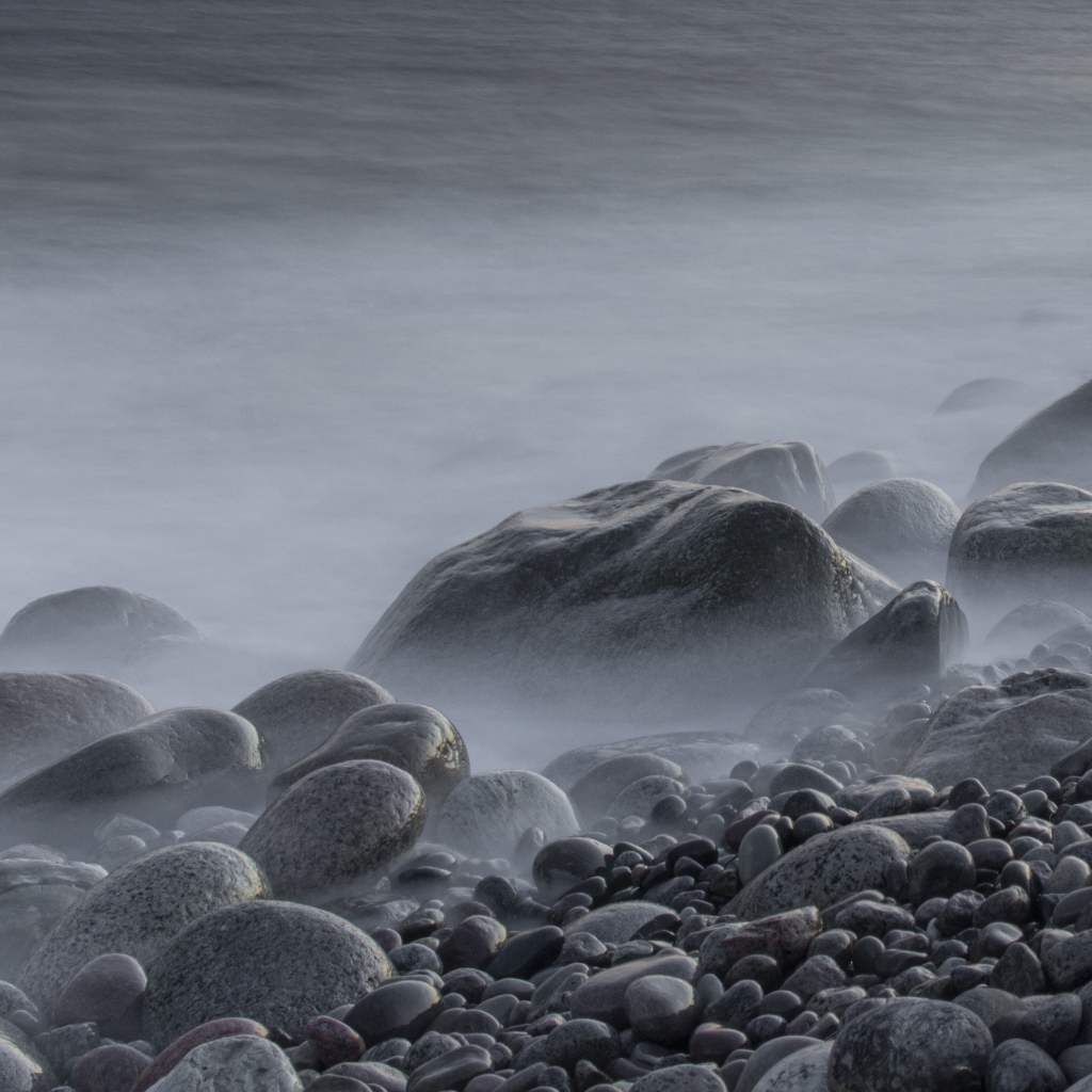 Большие черные камни на берегу моря в тумане