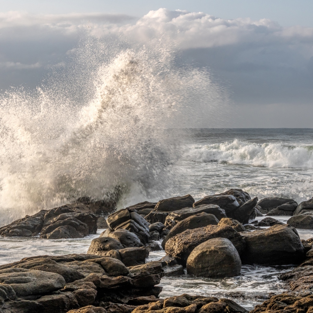 Морские волны бьются о камни на берегу
