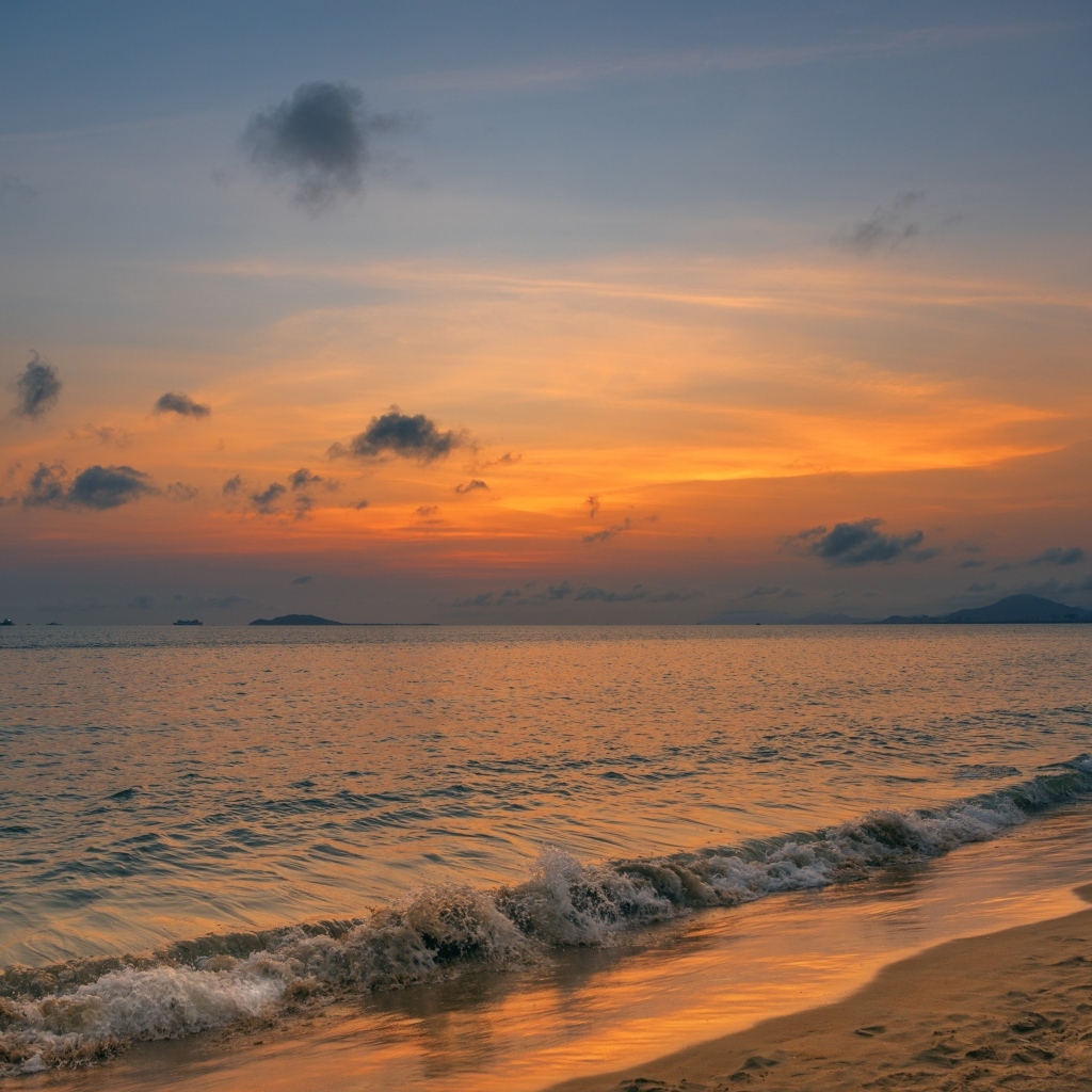 Морские волны омывают берег на закате