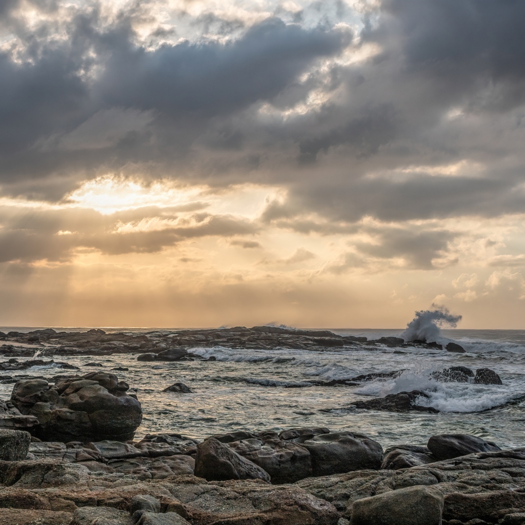 Лучи солнца пробиваются сквозь тучи над морем