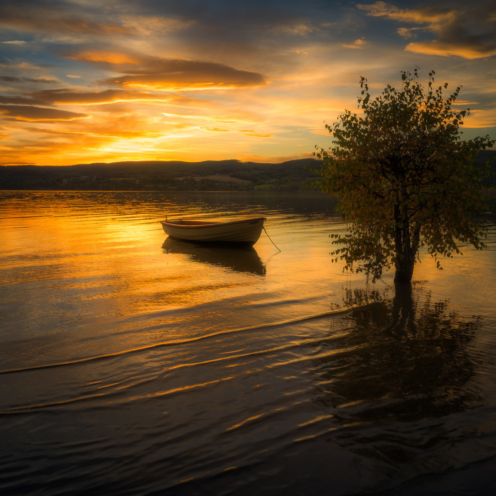 Лодка в воде спокойного озера на закате солнца
