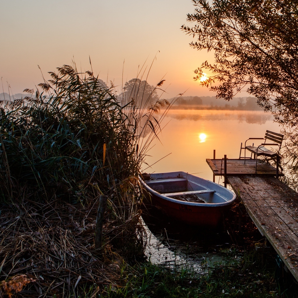 Лодка на берегу озера на закате 