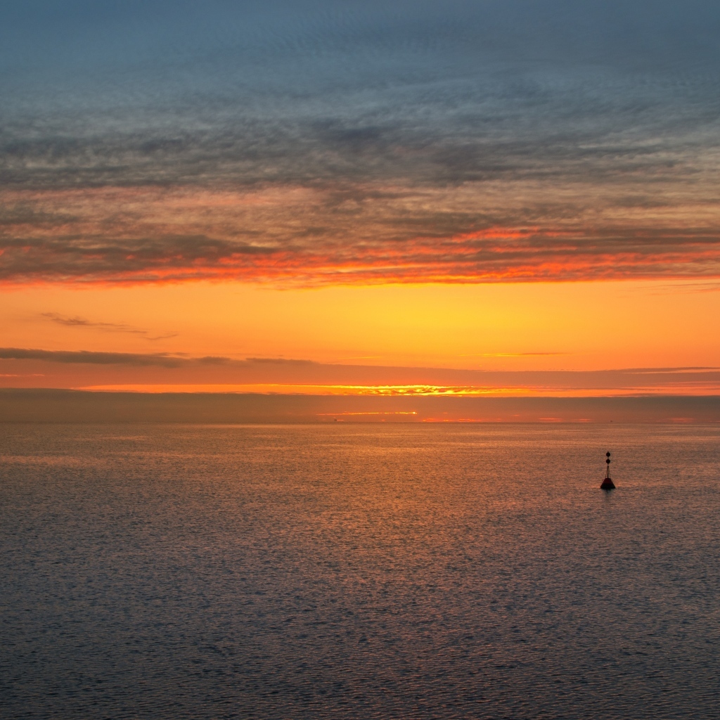 Яркий оранжевый закат на морском горизонте