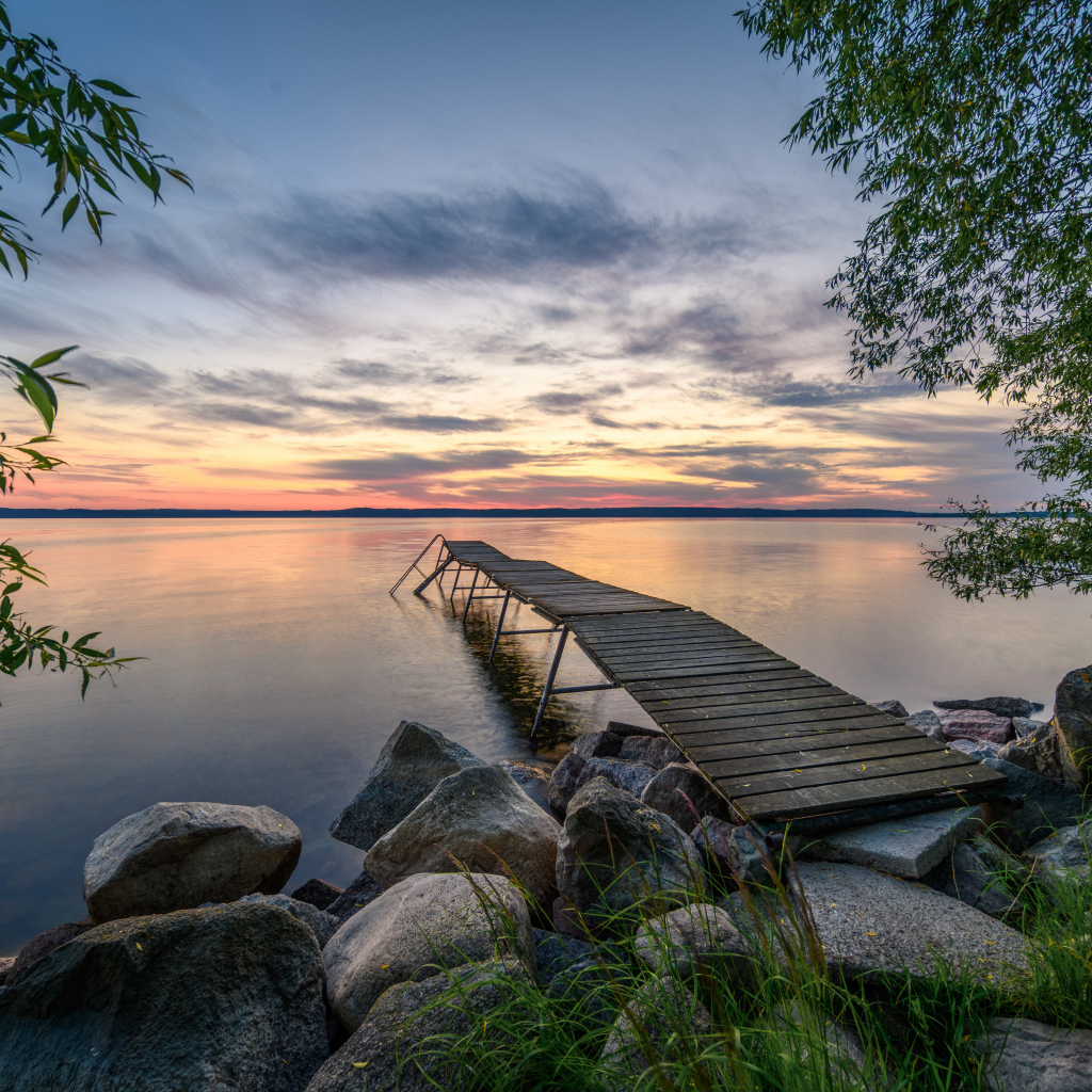 Старый деревянный пирс у озера на закате