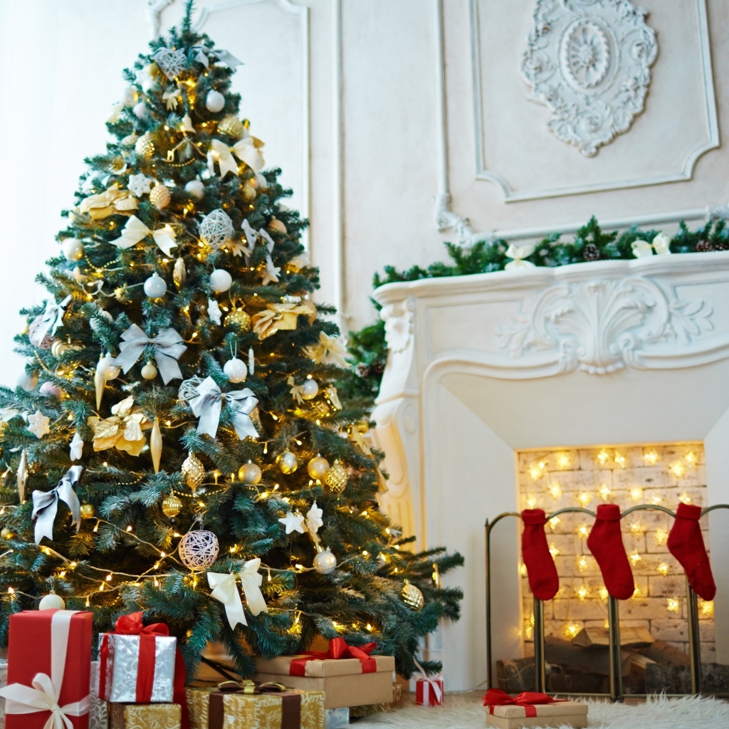 Красивая наряженная ель в комнате с камином