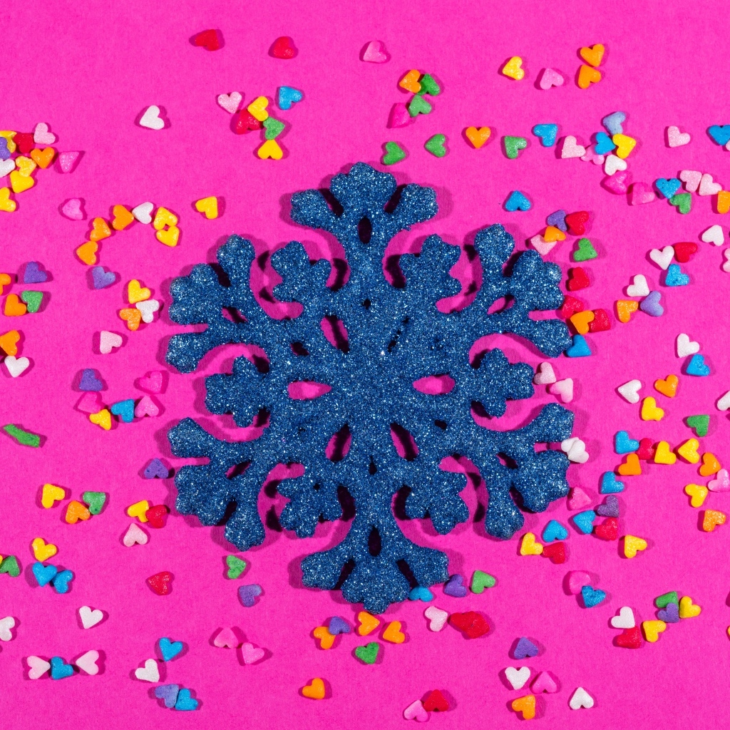 Большая синяя снежинка на розовом фоне с сердечками