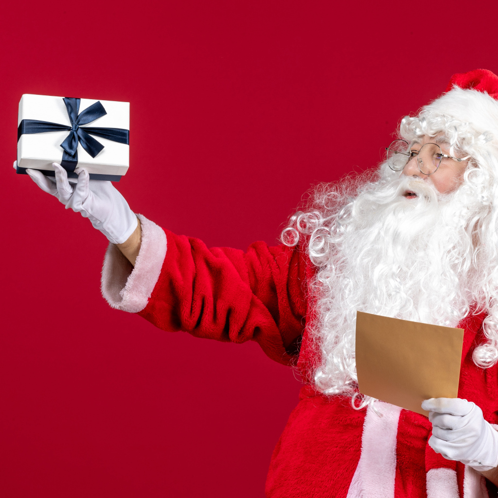 Санта Клаус с письмом на красном фоне