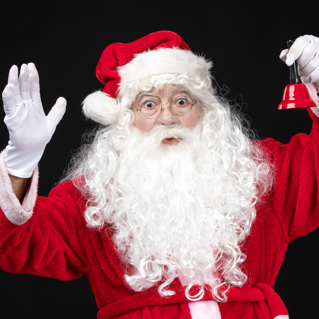 Удивленный Санта Клаус с колокольчиком в руках