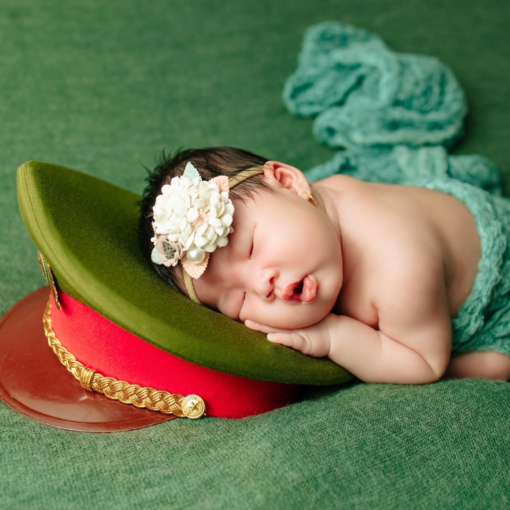 Маленький ребенок спит на военной фуражке