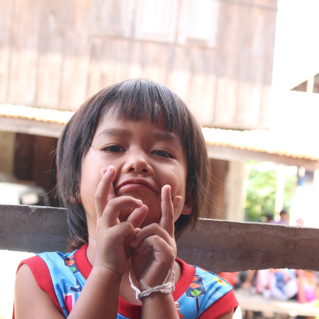 Девочка азиатка с руками  у лица