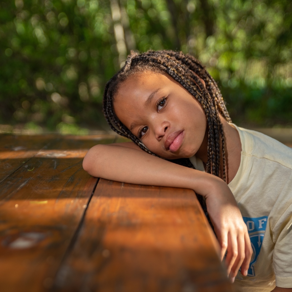 Красивая темнокожая девочка с косичками на голове 