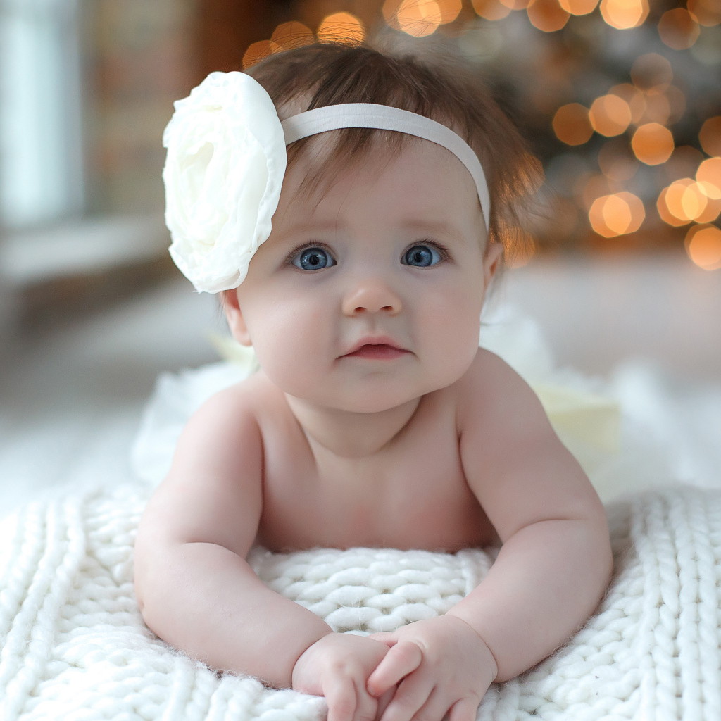 Красивая маленькая девочка с белым цветком на голове