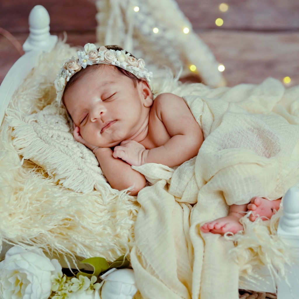 Красивая новорожденная девушка с венком на голове 