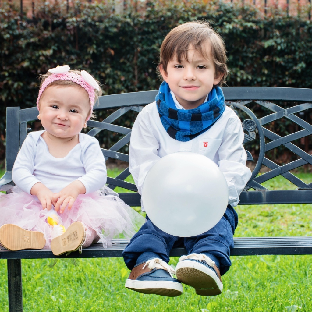 Мальчик и девочка сидят на лавке в парке