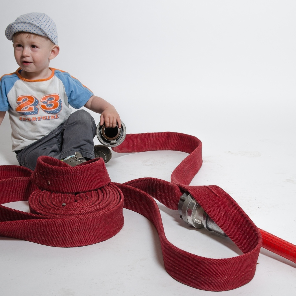 Мальчик с красным пожарным шлангом