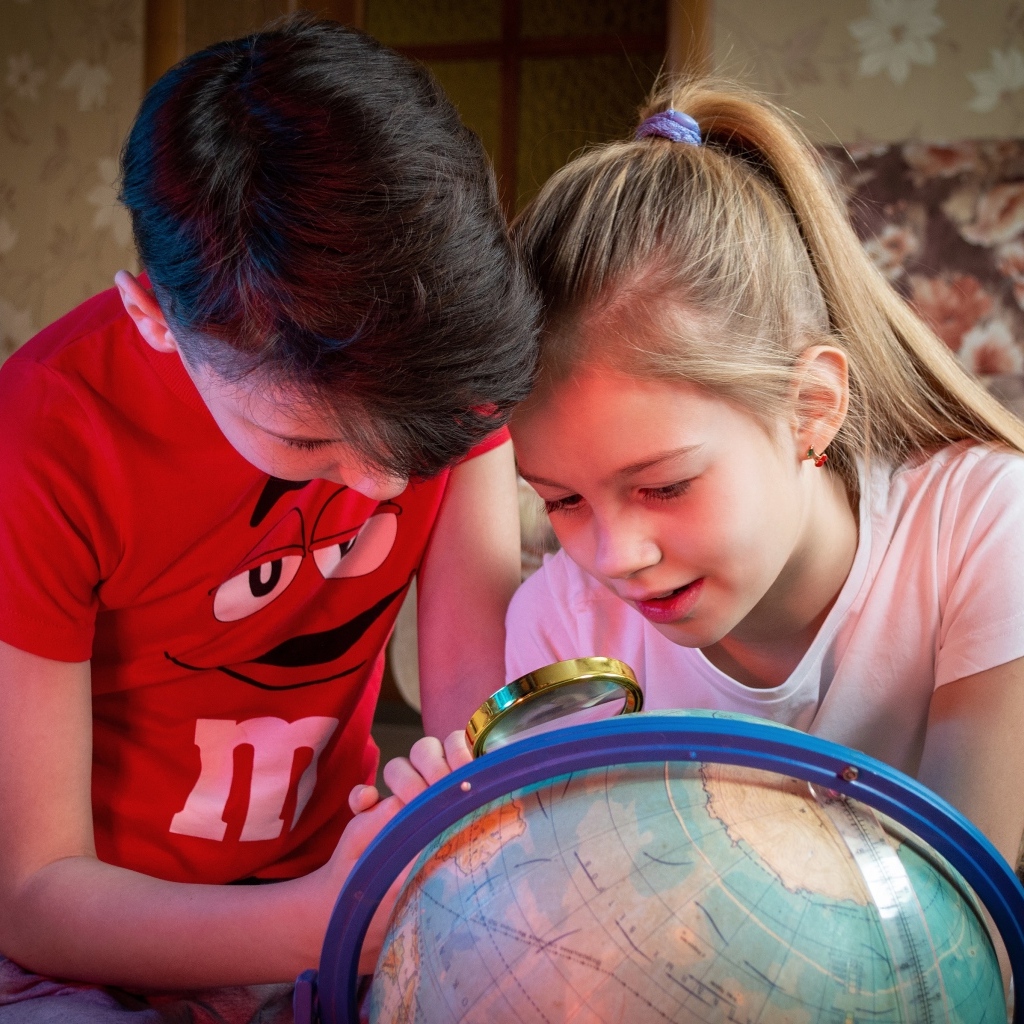 Дети школьники изучают глобус