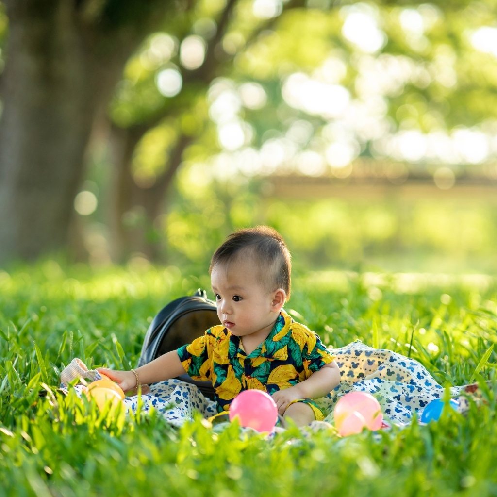 Милый маленький ребенок сидит на траве
