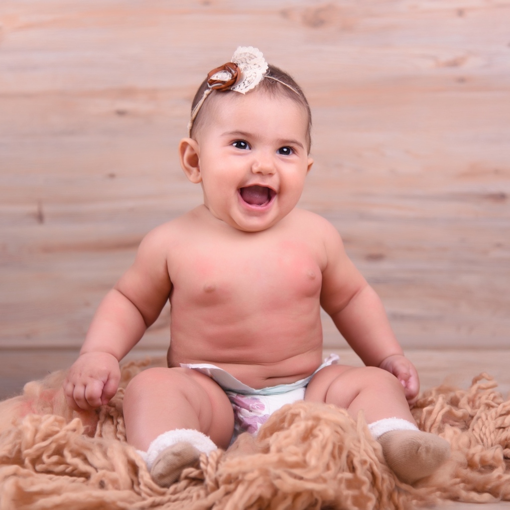 Милый улыбающийся ребенок на фоне деревянной стены