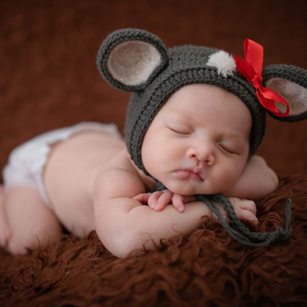 Смешная шапка на голове спящей малышки