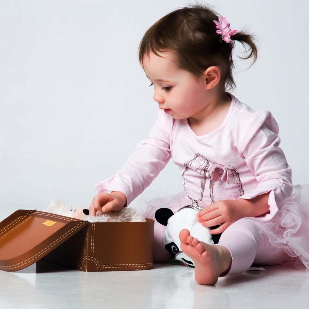 Девочка в розовом наряде с маленьким чемоданом